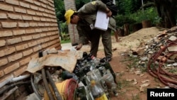 FILE - A member of the SENEPA (National Malaria Eradication) inspects a house in Villa Elisa city near Asuncion, Paraguay, Jan. 9, 2013.