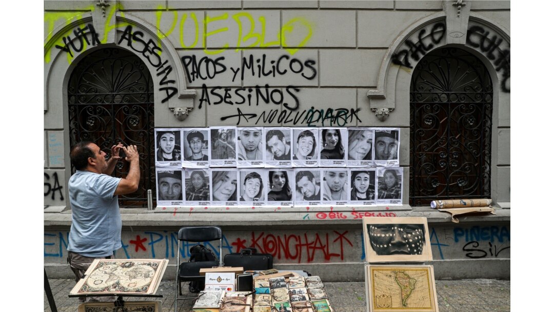 A man takes a photo of portraits of people that have died during anti-government protests in Santiago, Chile, Nov. 1, 2019.