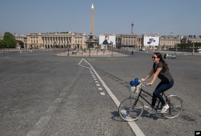 A woman crosses the Concorde square as she rides a bike during a nationwide confinement to ｃounter the new coronavirus in Paris, Friday, April 10, 2020. (AP photo)