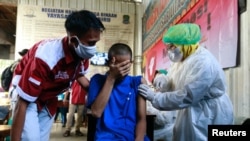 Reaksi seorang pasien gangguan jiwa yang dirawat oleh Yayasan Jamrud Biru saat menerima vaksin COVID-19 dalam program vaksinasi di Bekasi, pinggiran Jakarta. (Foto: Reuters)