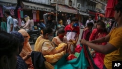 People shop at a market ahead of Eid-al Adha festival in Jammu, India, July 18, 2021.