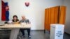 Members of the election committee wait for voters at a polling station in Ocova, near Zvolen, Slovakia, during European Parliament elections on June 8, 2024.