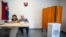 Members of the election committee wait for voters at a polling station in Ocova, near Zvolen, Slovakia, during European Parliament elections on June 8, 2024.
