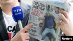 A reporter holds up a local newspaper during his report in front of the morgue at Kuala Lumpur General Hospital where Kim Jong Nam's body is held for autopsy in Malaysia, Feb. 18, 2017.