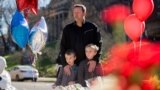 A man and his two sons are seen at a memorial outside the gates of the French Embassy in Washington, Nov. 15, 2015.
