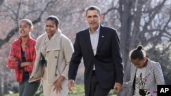 President Barack Obama, with first lady Michelle Obama and daughters Malia, 12, left, and Sasha, 9, right, return to the White House in Washington, 4 Jan 2011