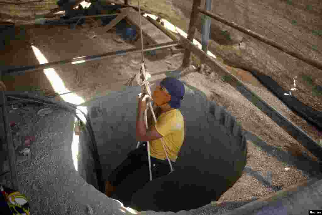 A Palestinian tunnel worker is lowered on a rope into a smuggling tunnel dug beneath the Gaza-Egypt border in the southern Gaza Strip. Egyptian security forces have cracked down on the tunnels since July.