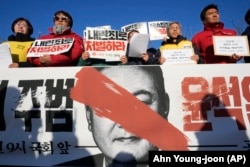 Protesters stage a rally to demand South Korean President Yoon Suk Yeol to step down in front of the National Assembly in Seoul, South Korea, Wednesday, Dec. 4, 2024.