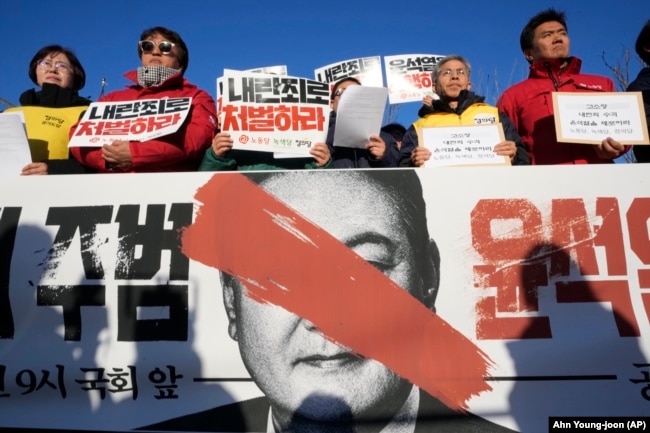 Protesters stage a rally to demand South Korean President Yoon Suk Yeol to step down in front of the National Assembly in Seoul, South Korea, Wednesday, Dec. 4, 2024.