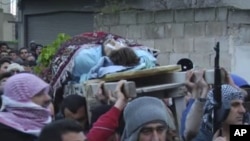 This image taken from video filmed over the past several days by an independent cameraman and made available February 7, 2012 shows a man carried outside in a funeral procession in Homs, Syria.