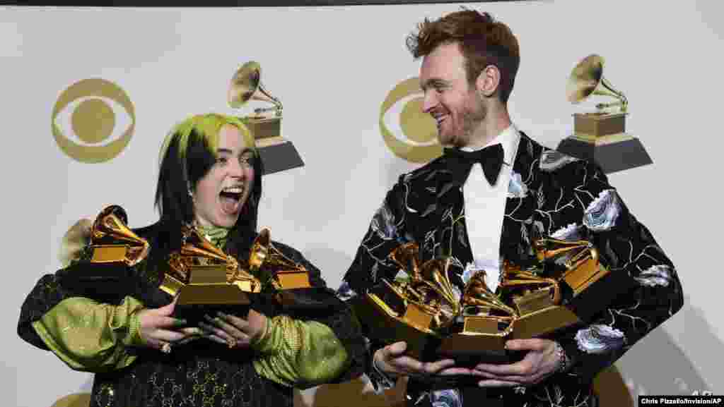 Billie Eilish, left, and Finneas O&#39;Connell pose in the press room with the awards for best album, best engineered album and best pop vocal album for &quot;We All Fall Asleep, Where Do We Go?,&quot; best song…