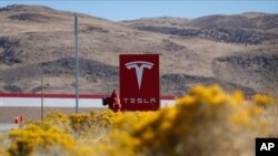 FILE - A sign marks the entrance to the Tesla Gigafactory in Sparks, Nevada, Oct. 13, 2018. 