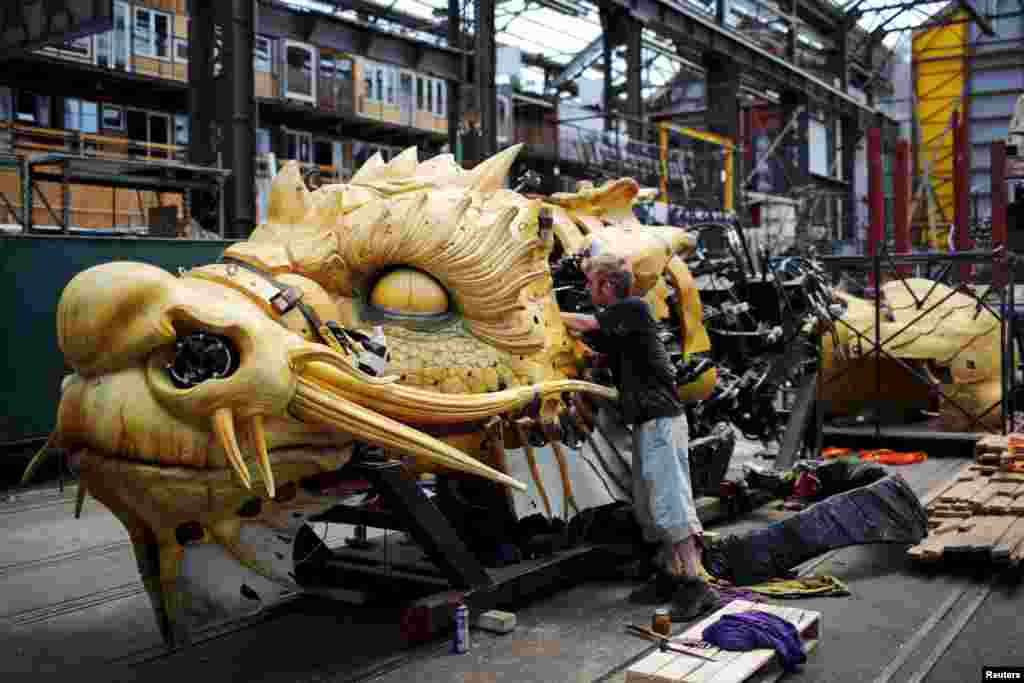A man works on "Long Ma", a creation by La Machine production company, during a media visit to "A Journey to Nantes" (Le Voyage a Nantes) art festival in Nantes, France, June 30, 2015.