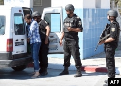 Tunisian security forces man a checkpoint at the entrance of the resort area on the outskirts of Sousse south of the capital Tunis following a shooting attack at the beach resort Friday, June 27, 2015.