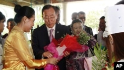 U.N. Secretary-General Ban Ki-moon, center left, and his wife Yoo Soon-taek, center right, receive flowers from a staff upon their arrival at a hotel Sunday, April 29, 2012 in Yangon, Burma.
