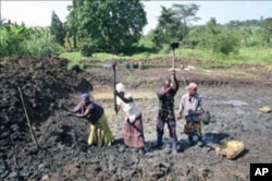 A team of people in the community puts the finishing touches on a pond, one of four they have dug over the last year as part of a community fish-farming business, in Naminya, Uganda, December 2011.