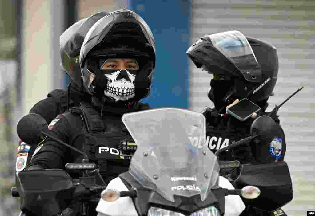 Police officers ride a motorbike during a police operation in Duran, Ecuador.