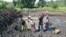 FILE - A team of people puts the finishing touches on a pond, one of four they have dug over the last year as part of a community fish-farming business, in Naminya, Uganda.