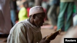 A man prays while reading verses from the Koran in a hangar at the airport of the capital Bangui January 30, 2014. The hangar is used to shelter internally displaced Muslims fleeing the continuing sectarian violence and those waiting to be evacuated. (Photo: Reuters)