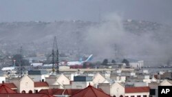 Asap mengepul dari lokasi ledakan di luar bandara di Kabul, Afghanistan, 26 Agustus 2021. (AP Photo/Wali Sabawoon)