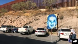 A portrait of 16-year-old Mexican youth Jose Antonio Elena Rodriguez, who was shot and killed in Nogales, Sonora, Mexico, is displayed on the street where he was killed that runs parallel with the U.S. border, Dec. 14, 2017. A U.S. border patrol agent is going on trial for second-degree murder in U.S. District Court in Tucson, March 20, 2018.