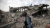 FILE - An Afghan policeman walks at the site a truck bomb blast in Kabul, Aug. 7, 2015. A U.S. Green Beret admitted killing a man in Afghanistan he suspected was a bombmaker. There is enough evidence to charge him with murder.