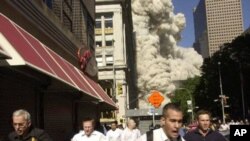 People run from the collapse of World Trade Center Tower in New York City on September eleventh, 2001
