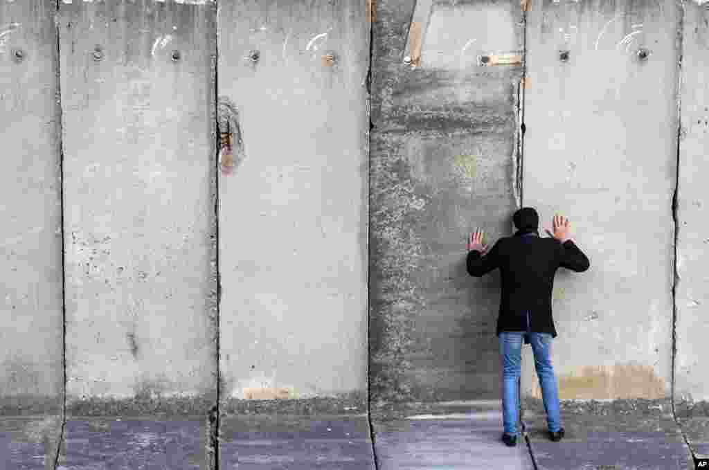 A man looks through a space during the art performance &quot;Wall watching &mdash; climb the wall together&quot; of the National Theatre Weimar, ahead of the 30th anniversary of the fall of the Berlin Wall, in Weimar, Germany.