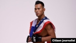 Andre Soukhamthath, a Lao-American UFC fighter holds a Lao and American flag.