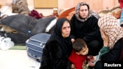 Civilians who escaped from Islamic State militants rest at a mosque in Raqqa, Syria, Oct. 12, 2017.