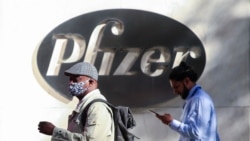 People walk by the Pfizer world headquarters in New York on Nov. 9, 2020.