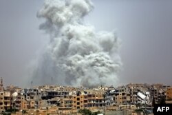 FILE - Smoke billows out from Raqqa following a U.S.-led coalition airstrike, July 28, 2017.