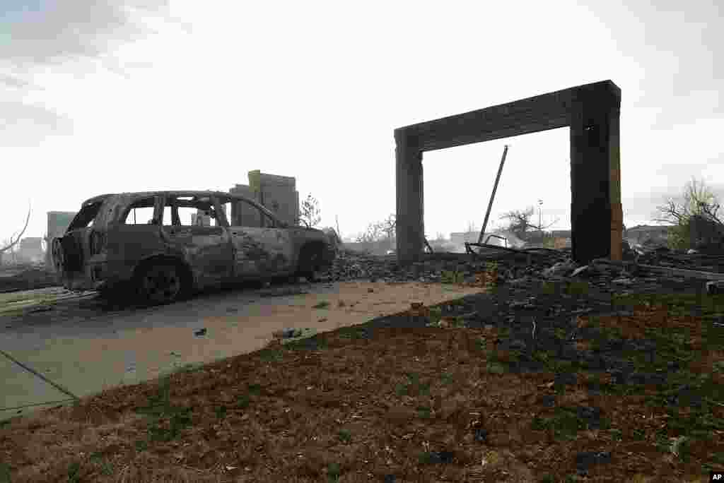 A burnt out car sits in front of a smoldering home, in Superior, Colo. An estimated 580 homes, a hotel and a shopping center have burned and tens of thousands of people were evacuated in wind-fueled wildfires outside Denver.