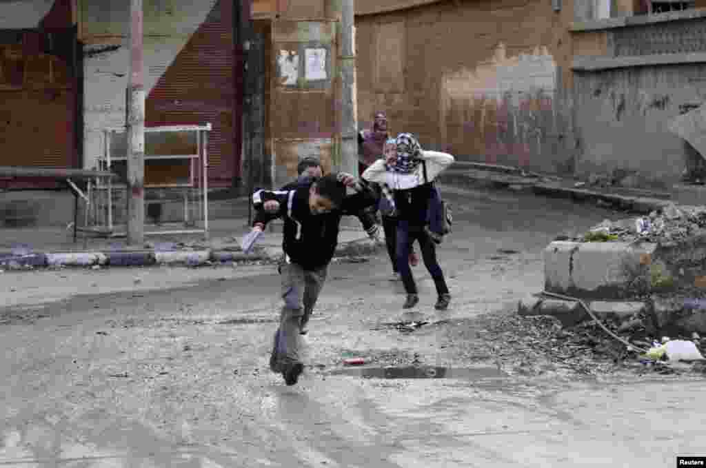 Children run across a street to avoid snipers in Deir al-Zor, eastern Syria Feb. 16, 2014. 
