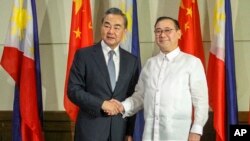 New Philippine Foreign Affairs Secretary Teodoro Locsin Jr., right, and visiting Chinese Foreign Minister Wang Yi shake hands during the latter's courtesy call in Davao city, southern Philippines Monday, Oct. 29, 2018. 