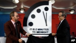 Robert Rosner, chairman of the Bulletin of the Atomic Scientists, right, and Bulletin of the Atomic Scientists member Lawrence Krauss, left, unveil the Doomsday Clock during a news conference at the National Press Club in Washington, Jan. 25, 2018. 