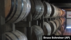 FILE - Bourbon ages in barrels at the Jim Beam distillery in Clermont, Kentucky, July 24, 2014.