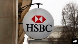 FILE - The logo of HSBC Bank is displayed on the facade of HSBC France headquarters on the Champs Elysees in Paris, Feb. 9, 2015.