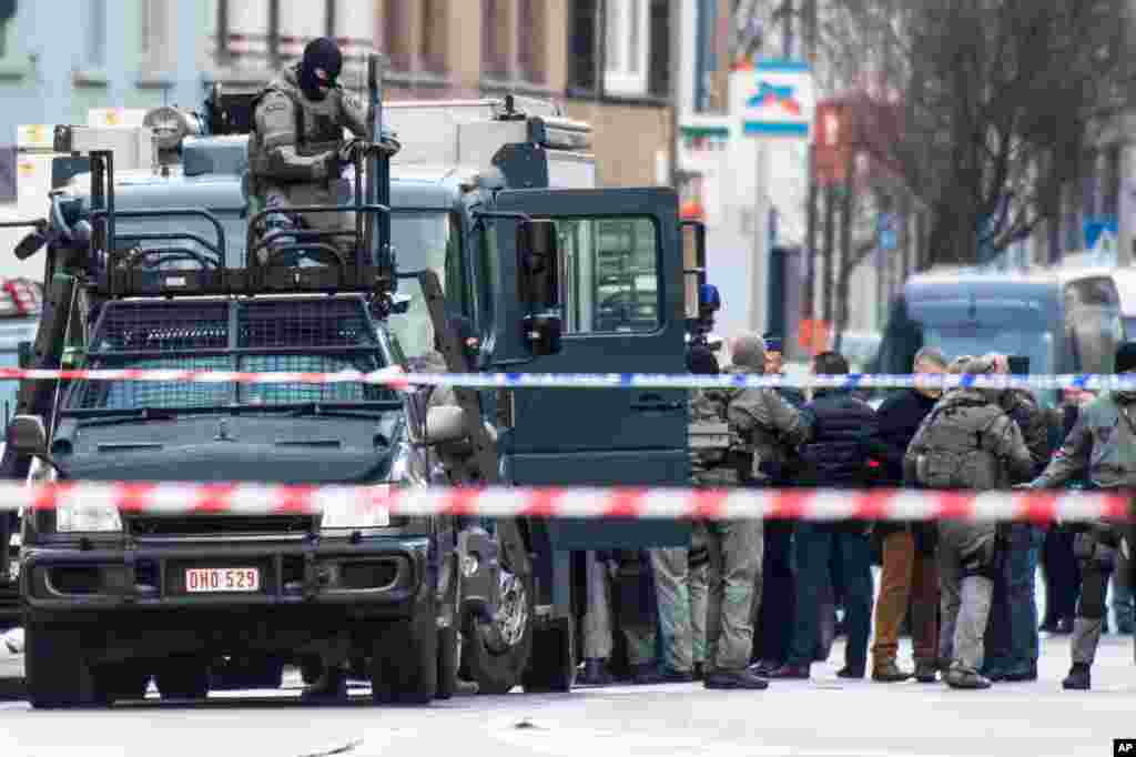 A member of the special forces police installs equipment on a van in Ghent, Belgium. Four armed men have entered an apartment, and police have blocked off a wide perimeter around the area. Police said that three hours after the men entered the apartment it was still unclear whether they had taken any hostages.