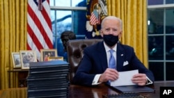 President Joe Biden pauses as he signs his first executive orders in the Oval Office of the White House on Wednesday, Jan. 20, 2021, in Washington. (AP Photo/Evan Vucci) Joe Biden