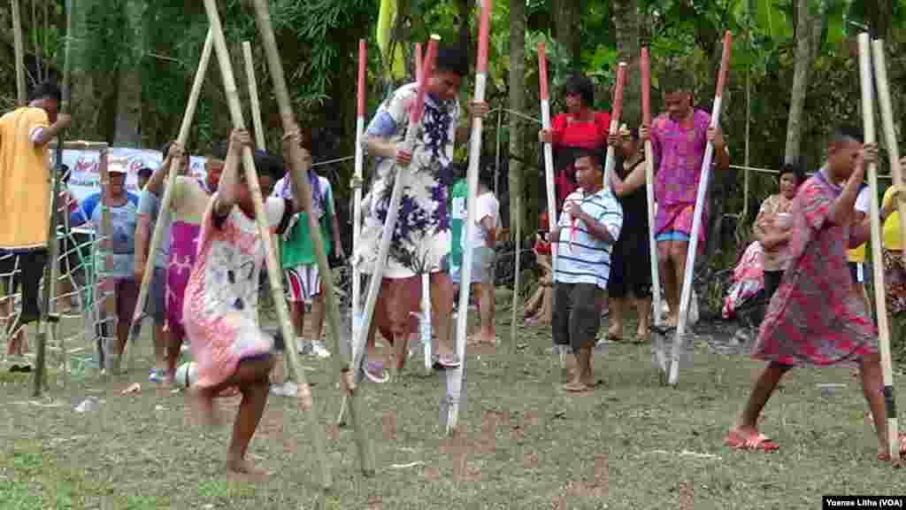 Warga Desa Maliwuko, Lage, Kabupaten Poso, Sulawesi, merayakan Ulang Tahun ke-73 Republik Indonesia dengan lomba sepak bola menggunakan egrang, 13 Agustus 2018. Dalam lomba tersebut, setiap tim yang beranggotakan 5 pemain laki-laki wajib menggunakan daster dengan wajah yang dipasangi lipstik. (Foto: Yoanes Litha/VOA)