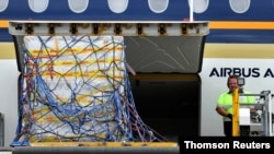 The first Australian shipment of Pfizer coronavirus disease (COVID-19) vaccines is unloaded from a Singapore Airlines plane at Sydney International Airport