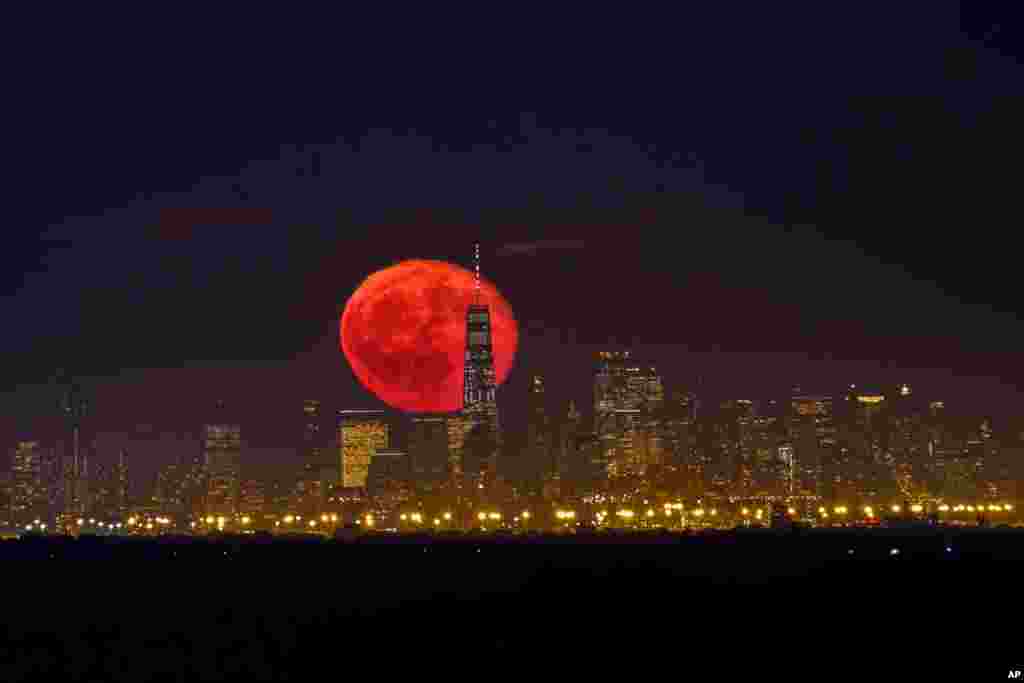 The moon rises behind One World Trade Center on a clear night in the lower Manhattan neighborhood of New York, as seen from Green Brook Township, New Jersey, Oct. 15, 2019. 