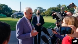 President Joe Biden speaks with members of the press before boarding Marine One on the South Lawn of the White House, in Washington, Oct. 2, 2021.