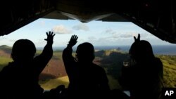 지난해 12월 미국 공군과 일본 항공자위대원들이 북마리아나 제도 파간섬 주민들을 위한 크리스마스 선물을 공중에서 투하한 후 주민들을 향해 손을 흔들고 있다. (자료사진)