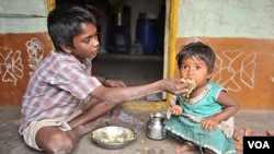 Seorang anak laki-laki menyuapi adiknya di kawasan miskin di Hyderabad, India. PM Manmohan Singh mengatakan tingginya angka malnutrisi merupakan aib negara (foto:dok).