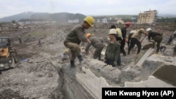 Workers recover cement blocks from flood-damaged areas in Onsong, North Hamgyong Province, North Korea.