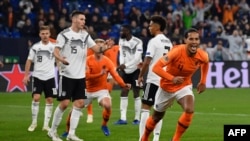 Bek Belanda Virgil van Dijk (kanan) merayakan skor imbang 2-2 dalam laga UEFA Nations League antara Jerman vs Belanda di Gelsenkirchen, 19 November 2018.