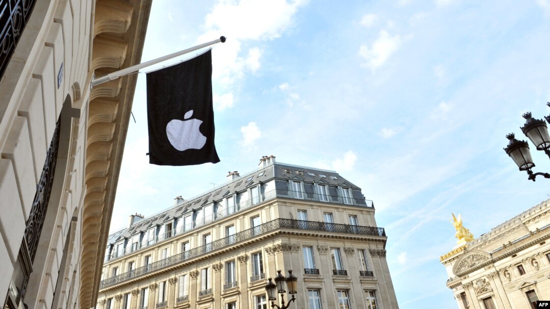 Bendera dengan logo perusahaan Apple terlihat di luar toko Apple di Paris, Prancis (foto: dok). 