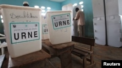 A voter fills out his ballot behind a privacy screen at a polling station in the Cocody neighborhood of Abidjan, April 21, 2013.